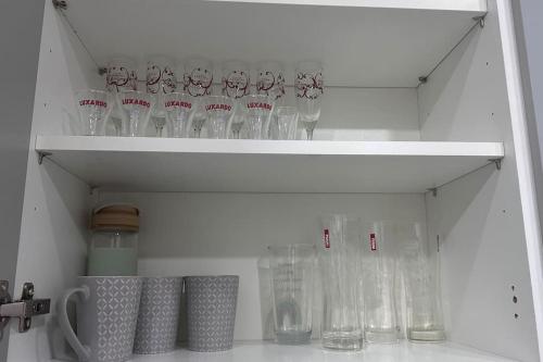 a white shelf filled with glasses in a refrigerator at Kilburn Hideaway Family and Pet-Friendly Apartment in Cosmopolitan Locale in London