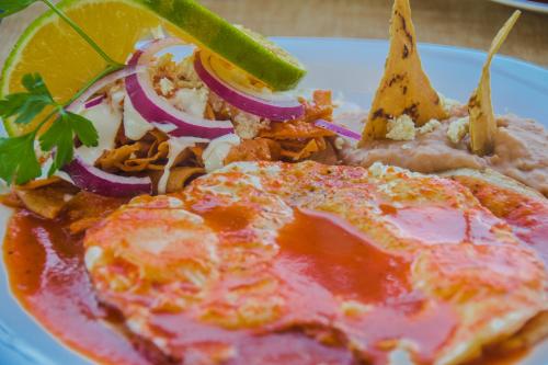 a plate of food with a pizza and vegetables at Hotel Suites Nadia Puerto Vallarta in Puerto Vallarta