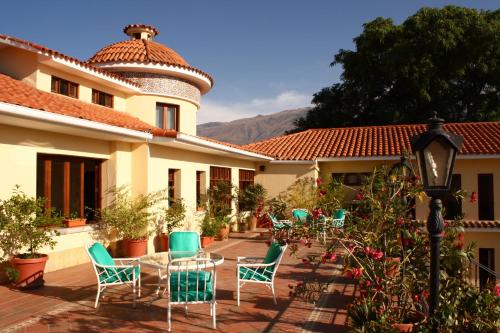 un patio con sillas y una mesa frente a un edificio en Hotel Aranjuez Cochabamba, en Cochabamba