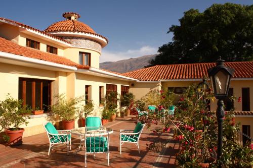 a patio with chairs and a table in front of a building at Hotel Aranjuez Cochabamba in Cochabamba