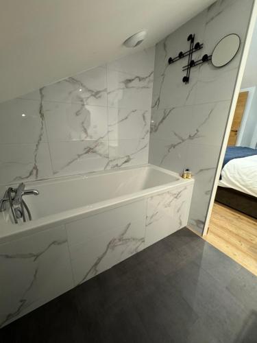 baño con bañera blanca y paredes de mármol en La Grange de Witry en Witry-lès-Reims
