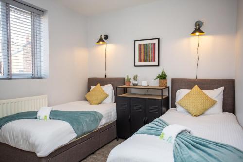 1 dormitorio con 2 camas y escritorio en Whitey Bay Coastal Bliss, en Whitley Bay