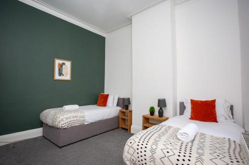 2 Betten in einem Zimmer mit grünen und weißen Wänden in der Unterkunft High Barnes Haven 3br Retreat in Sunderland