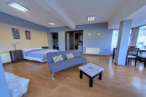 1 dormitorio con cama, sofá y mesa en Patagonia apartments - Ushuaia Center en Ushuaia