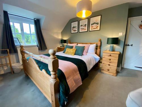 een slaapkamer met een houten bed en een raam bij Quarry House in Presteigne
