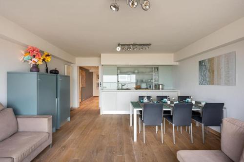 een keuken en eetkamer met een tafel en stoelen bij Seafront apartment 2 bed Duinbergen in Knokke-Heist