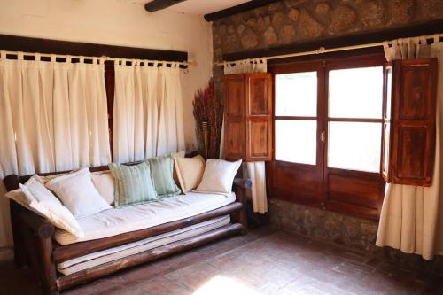 salon z kanapą i oknem w obiekcie Los Abuelos w mieście Anillaco