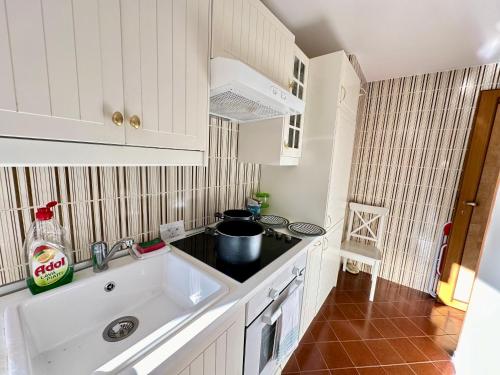 una cucina bianca con lavello e fornello di Luxury 4beds ski-in&out LARGE! a Breuil-Cervinia