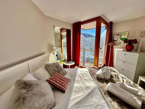 una camera da letto con un letto con cuscini e una finestra di Luxury 4beds ski-in&out LARGE! a Breuil-Cervinia