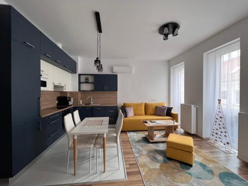 uma cozinha e sala de estar com um sofá amarelo em One Step Apartman - City Center with Self Check-In em Szombathely