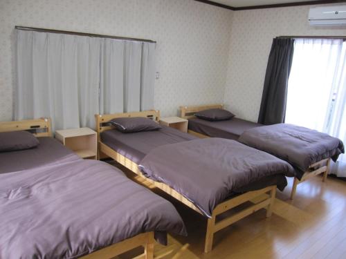 a room with three beds and a window at GuestHouse AZMO - Vacation STAY 35375v in Matsue