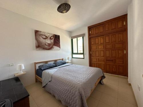 una camera con un letto e una grande porta in legno di Casa Alondras ad Arona