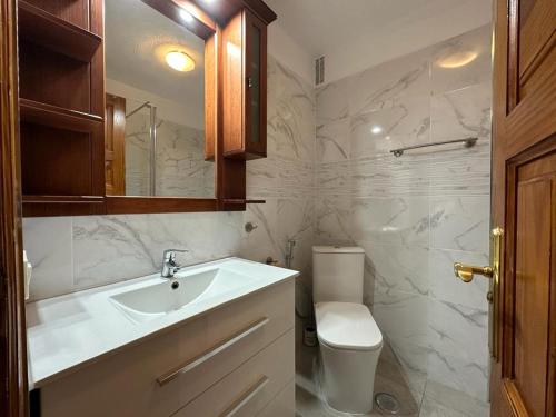 bagno bianco con lavandino e servizi igienici di Casa Alondras ad Arona