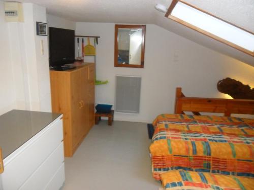 une chambre avec un lit et une télévision dans l'établissement Maison saisonnière de Mer, à Plage-des-Demoiselles