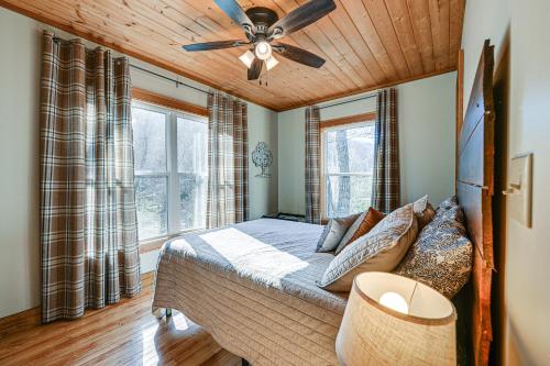 a bedroom with a bed with a ceiling fan at Bryson City Cabin Deck and Mountain-View Hot Tub in Nantahala