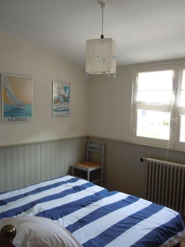 - une chambre avec un lit rayé bleu et blanc dans l'établissement CARNAC-Plage 12 personnes à 2mn à pied de la plage, à Carnac