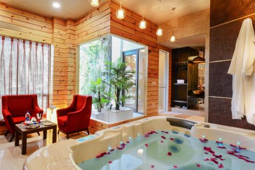 a bathroom with a tub and two red chairs at Honeymoon Inn Shimla in Shimla