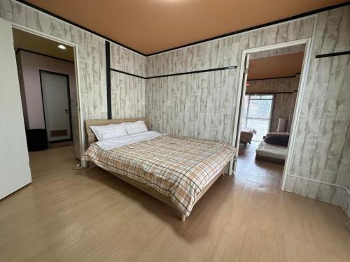 1 dormitorio con cama y espejo. en Calm House Beppu Kitahama - Vacation STAY 06895v, en Beppu