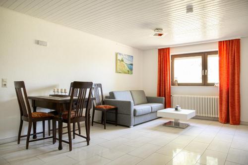 a living room with a couch and a table and chairs at Lakeside Apartment - Seeufer Apartment in Allensbach