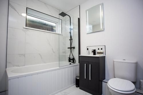 ein Badezimmer mit einer Badewanne, einem WC und einem Waschbecken in der Unterkunft Heart Of South Shields Modern Interior 2 Bed Flat in Westoe