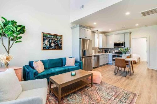 a living room with a blue couch and a kitchen at Pelican house*King bed*Fast WiFi*Book now in Lafayette