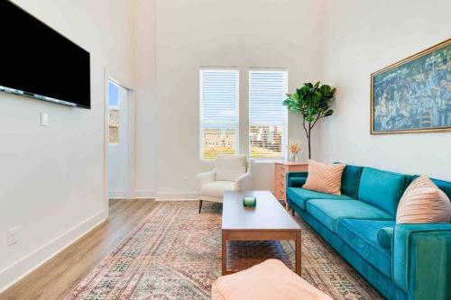 a living room with a blue couch and a tv at Pelican house*King bed*Fast WiFi*Book now in Lafayette