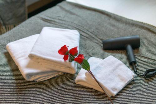 a pile of towels with a red flower on top at Nadeshiko Machiya - Vacation STAY 27197v in Fukuoka