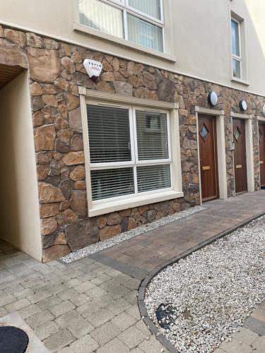a stone facade of a building with a window at Ballycastle, Beachside Apartment in Ballycastle