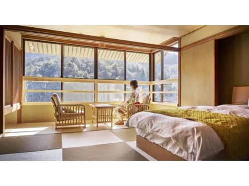 a person sitting in a room with a large window at Mansuirou - Vacation STAY 32150v in Misasa
