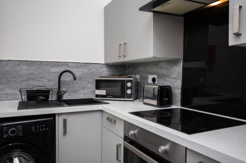 a kitchen with a sink and a microwave at The Ferndale Gf in Pallion