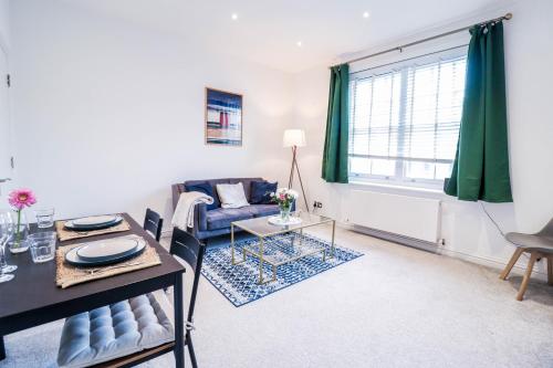 a living room with a table and a couch at Stylish 1 Bedroom Apartment in Central London in London