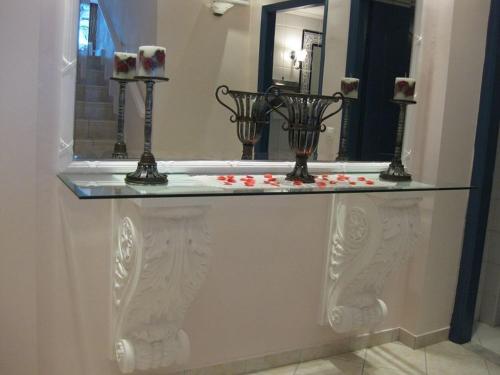 d'une baignoire avec un comptoir en verre et des roses. dans l'établissement Florena Hotel, à Nikiana