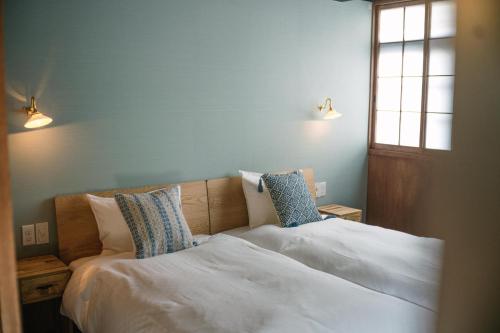 - une chambre avec un lit doté de draps et d'oreillers blancs dans l'établissement Casa OGUMO - Vacation STAY 34543v, à Kyoto