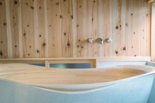 Cette chambre dispose de murs en bois et d'une baignoire. dans l'établissement Casa OGUMO - Vacation STAY 34543v, à Kyoto