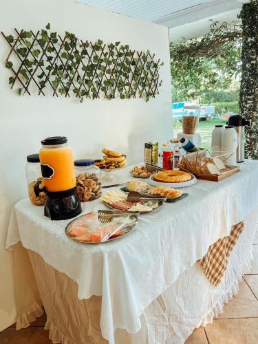 un tavolo bianco con sopra del cibo di Chácara Rosa Cortiana a São Gabriel