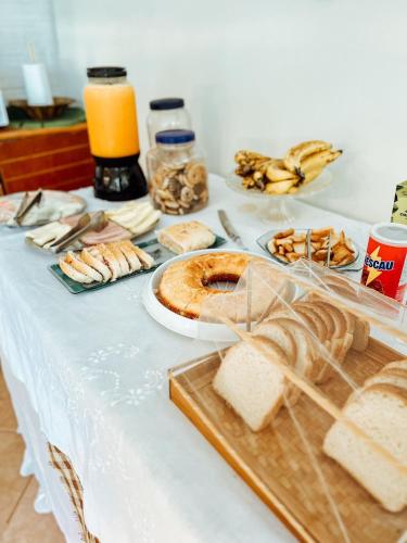 un tavolo con pane e altro cibo sopra di Chácara Rosa Cortiana a São Gabriel