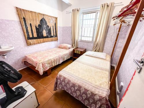 Cette petite chambre comprend 2 lits et un lavabo. dans l'établissement Toca da Mona Roots Hostel, à Vitória