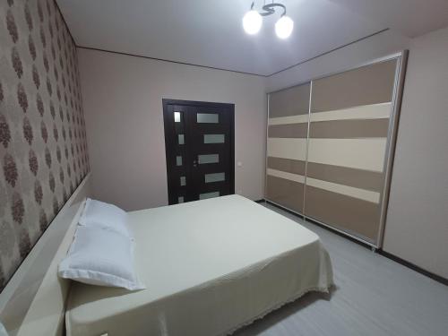 a bedroom with a white bed and a closet at Apartament in Chişinău