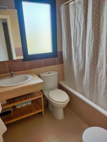 a bathroom with a toilet and a sink and a window at ATICO MORAIRA in Moraira