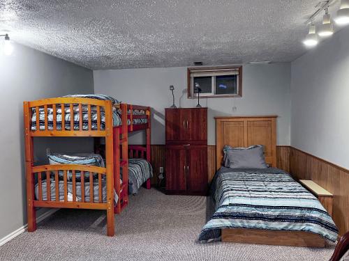 a bedroom with two beds and a bunk bed at Whitehorse Home on the River in Whitehorse