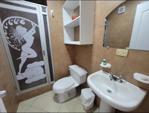 een badkamer met een toilet, een wastafel en een douche bij Hotel Arco Iris in Atacames