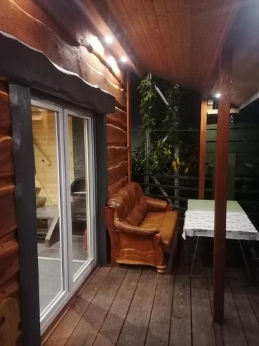 a patio with a chair and a table on a porch at Fala - Domki do wynajecia in Zagórze Śląskie