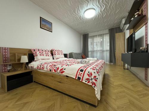 a bedroom with a large bed and a television at Apartment Studio Shevitsa 2 in Veliko Tŭrnovo