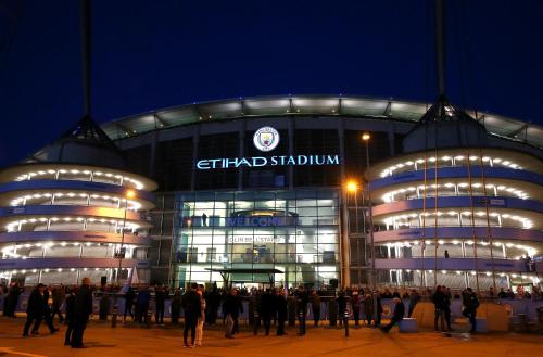 a group of people standing outside of a stadium at Private Modern Ensuite Room near Etihad Stadium in Manchester