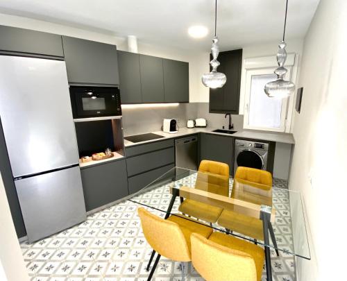uma cozinha com uma mesa de vidro e cadeiras amarelas em Bilbao old town flat EBI02425 em Bilbao