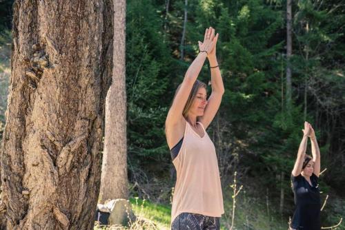 a woman is doing yoga next to a tree at Cosy Studio for 5 near ski lift, Les Gentianes in Les Collons