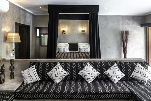 a couch with pillows sitting in a living room at Villa Le Petit Paradis Saly Boutique Hotel in Ngaparou