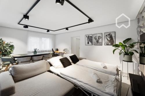 a living room with beds and a large light fixture at Day Young Life Apartment / DYL_Hosting in Nuremberg