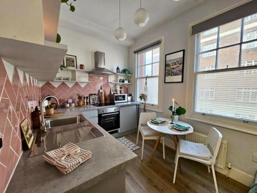 uma cozinha com um lavatório e uma mesa com cadeiras em Beautiful and spacious flat em Londres