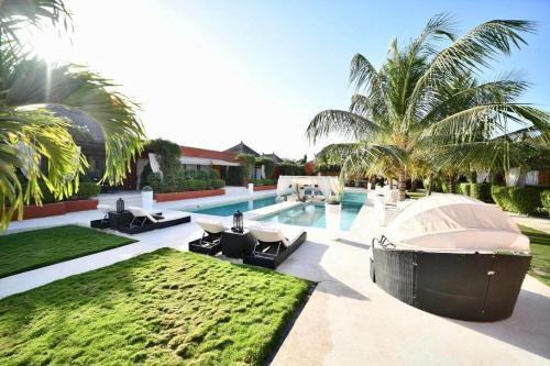 a swimming pool with chaise lounges and a resort at Villa Le Petit Paradis Saly Boutique Hotel in Ngaparou